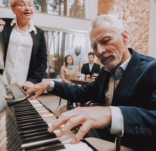 Older man playing the piano to audience